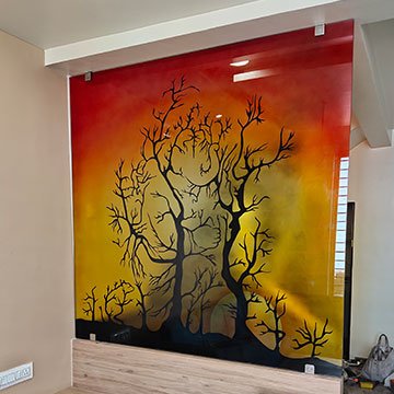 Back printed glass wall panel with a custom tree design installed in Anand