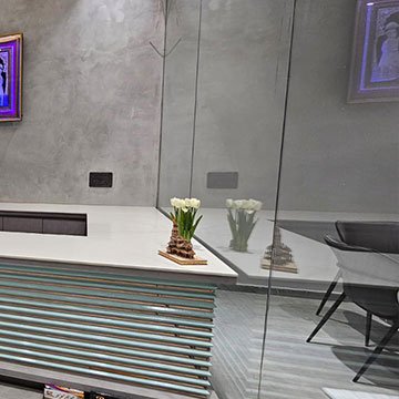 Frameless toughened glass partition beside a reception desk in Anand