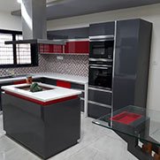 Modular kitchen with grey and red profile shutters and Godrej hardware in Anand